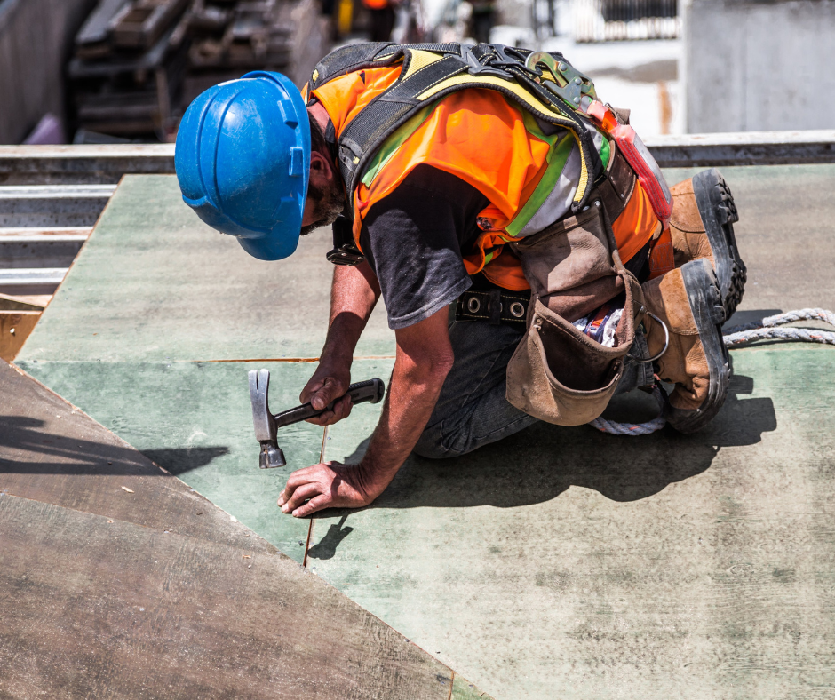 man using hammer on roof