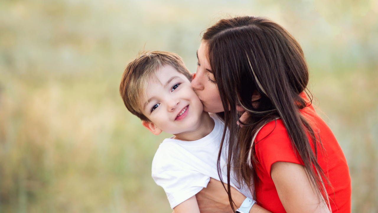 mother kissing child on cheek