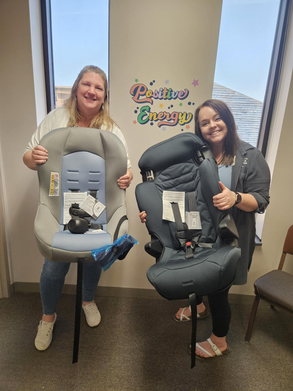 Public Health staff holding child car seats