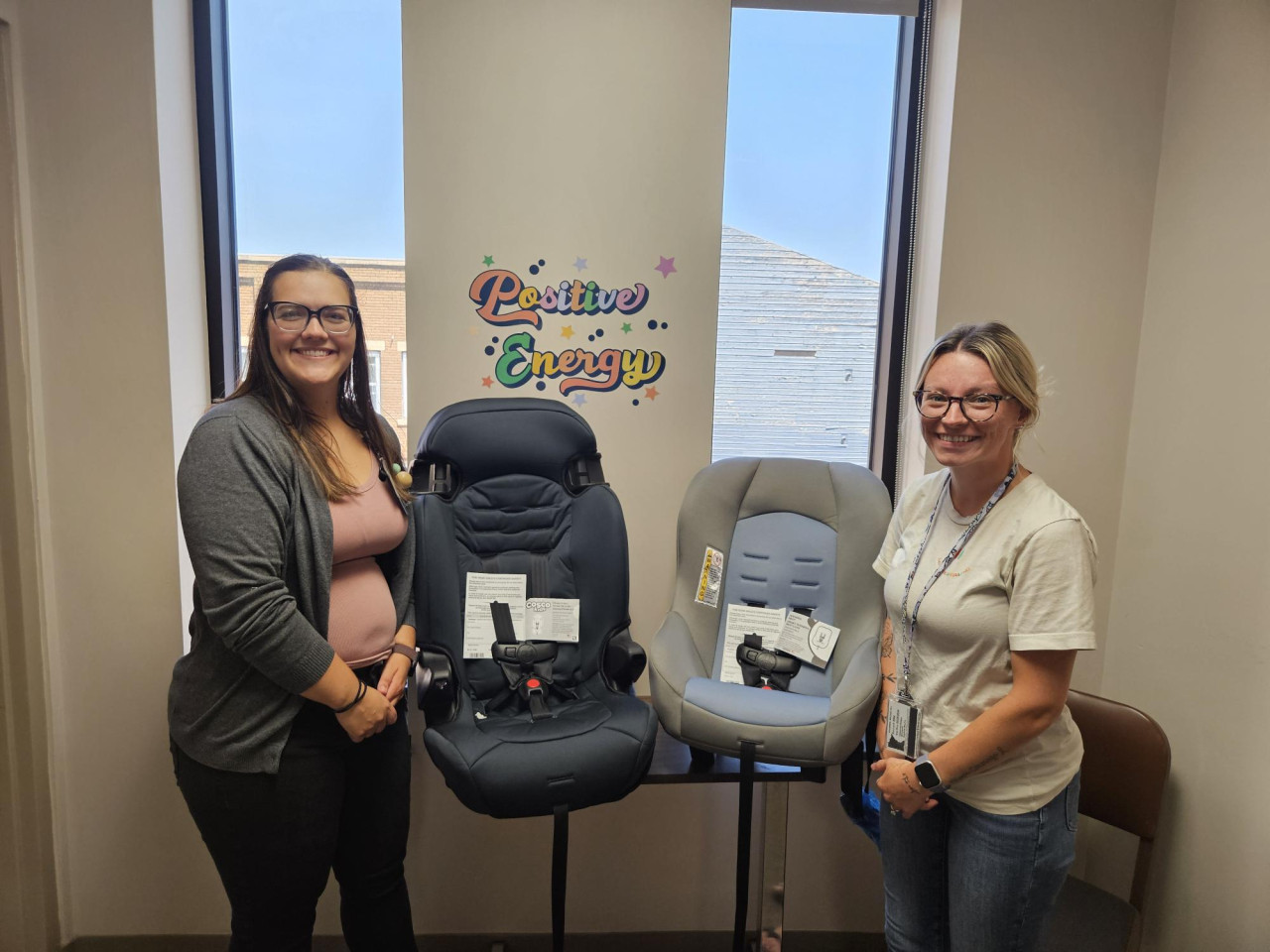 Public Health staff holding child car seats